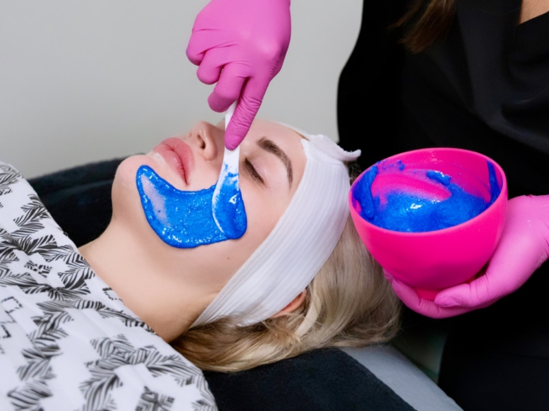Esthetician applying blue acne treatment mask at Skin Renew Co. in Grandville, MI