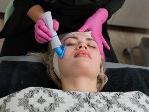 Esthetician performing a customized facial treatment at Skin Renew Co. in Grandville, MI