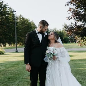 Bride with glowing skin and soft makeup smiling at her groom before their wedding ceremony