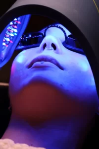 Client receiving blue LED light therapy under Celluma Pro device during facial treatment