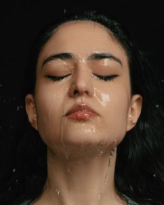 Woman with water on her face, symbolizing skin hydration